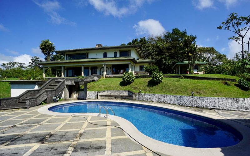 Luxushaus mit Pool und Garten am Arenalsee in Nuevo Arenal, umgeben von üppiger Vegetation.