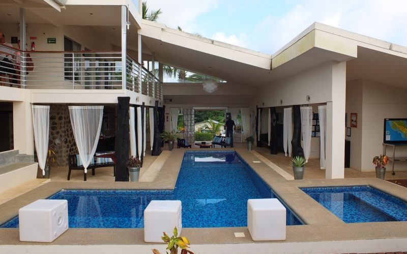 Innenhof eines Boutique-Hotels an der Pazifikküste mit Pool, Liegestühlen und Pflanzen.
