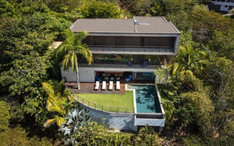 Luxuriöse Villa an der Playa Flamingo mit Pool und Terrasse, umgeben von tropischer Vegetation.