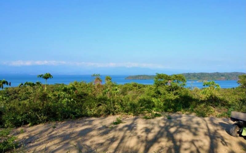 Blick auf die Küstenlandschaft bei Playa Naranjo mit üppiger Vegetation und Meer im Hintergrund.