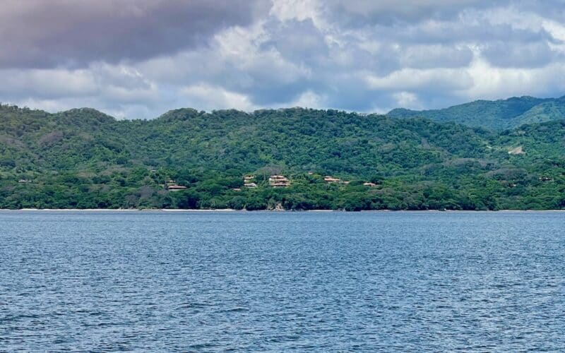 Blick auf die bewaldete Küste von Playa Naranjo mit dem Golf von Nicoya im Vordergrund.