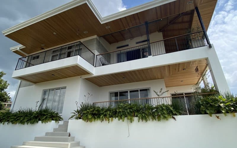 Modernes zweistöckiges Haus mit großen Balkonen und gepflegtem Garten in Alajuela, Zentraltal.