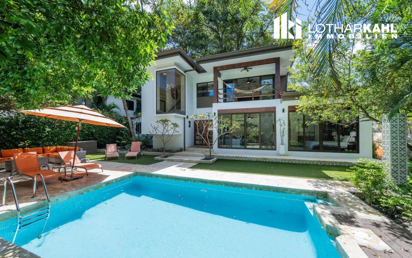 Moderne Villa mit Pool und Terrasse in Villarreal, umgeben von üppiger Vegetation.