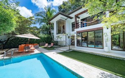 Moderne Villa mit Pool und Garten in Villarreal, umgeben von tropischen Bäumen.