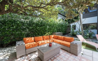 Terrasse einer Villa bei Tamarindo mit orangenen Sofas und Tisch unter Bäumen