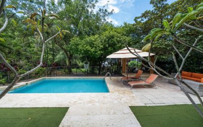 Poolbereich mit Liegestühlen und Pavillon in einer Villa bei Tamarindo, umgeben von üppiger Vegetation.