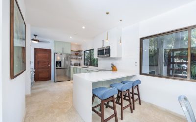 Moderne Küche mit Kochinsel, Barhockern und Edelstahlgeräten in einer Villa bei Tamarindo.