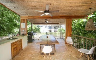 Überdachte Terrasse mit Holztisch, Stühlen, Grill und Waschbecken in einer Villa bei Tamarindo.