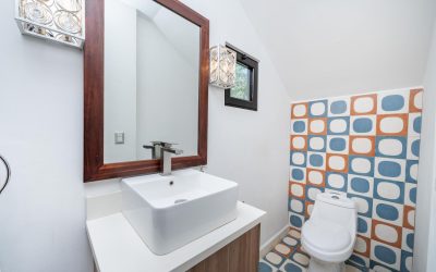 Modernes Badezimmer mit Waschbecken, großem Spiegel und bunten Fliesen in einer Villa bei Tamarindo.