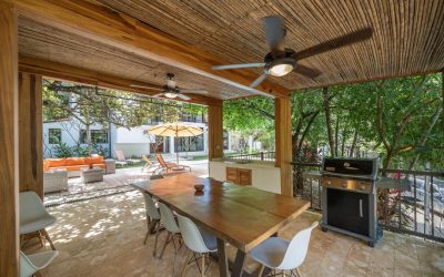 Überdachte Terrasse mit Esstisch, Stühlen, Grill und Blick auf den Garten in einer Villa bei Tamarindo.