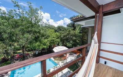 Blick von einem Balkon mit Hängematte auf einen Pool und üppige Vegetation in Villarreal, Pazifik Nord.