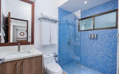Modernes Badezimmer mit blauen Fliesen, Dusche, Waschbecken und Spiegel in einer Villa bei Tamarindo.