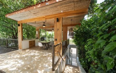 Überdachte Terrasse mit Esstisch und Grill in einer Villa bei Tamarindo, umgeben von üppigem Grün.
