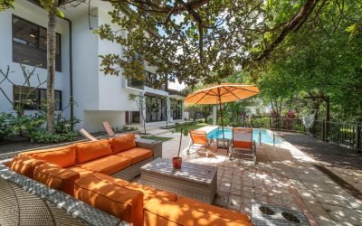 Terrasse einer Villa bei Tamarindo mit Pool, orangenen Sonnenliegen und Sitzbereich im Garten