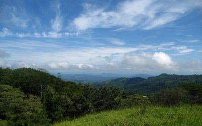 Landschaft mit grünen Hügeln und bewaldeten Flächen bei Monte Romo, Pazifik Mitte, unter blauem Himmel mit Wolken.
