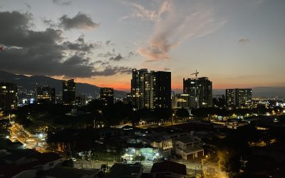 Städtische Skyline von Rohrmoser San Jose bei Sonnenuntergang mit beleuchteten Gebäuden.