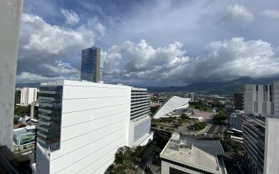 Blick vom 20. Stock auf moderne Gebäude in Rohrmoser San Jose mit Bergen im Hintergrund.